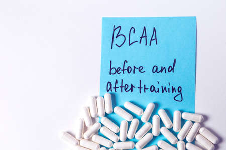 sport nutrition, supplements - bcaa in capsules and guide for it on the white background 