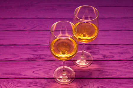 White wine in the wineglass on the purple wood backgroundの写真素材