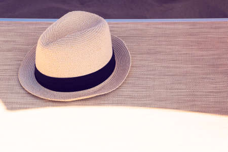 The summer hat on the beach lounge chair near the seaの写真素材