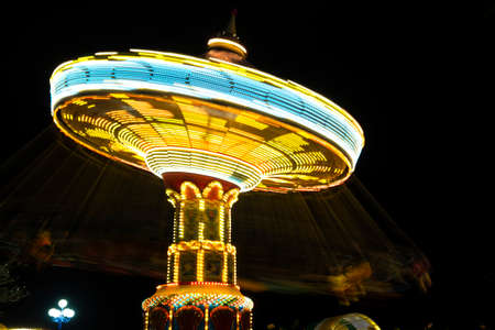 rotating with high speed carnival attraction chain with bright lights in amusement parkのeditorial素材
