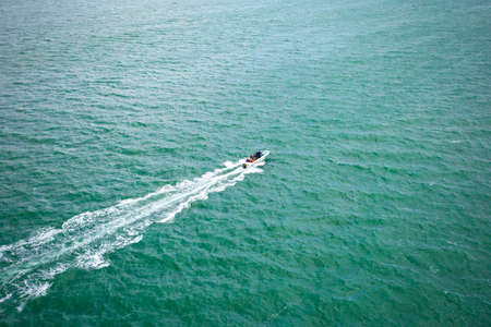 aerial view of fast motor boat sails on the boundless sea leaving a trail behind の写真素材