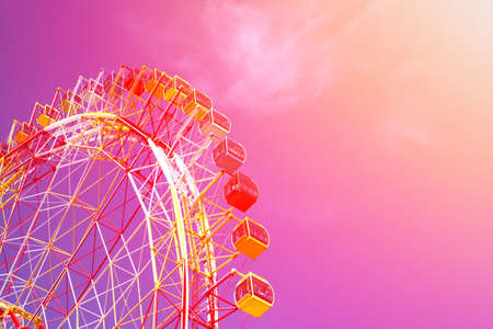 huge modern colorful bright ferris wheel in an amusement park on a blue sky background (toned)のeditorial素材