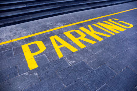 the word "parking" painted in yellow on gray asphaltの写真素材