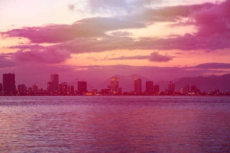 view from the South China Sea on the coast and the beach of night Nha Trang city, Vietnam with beautiful sunset sky の写真素材