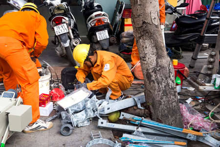 the engineers and workers with electricity (electricians) in uniform set up electrical equipment on the street in Nha Trang City, Vietnam 2018-01-09のeditorial素材
