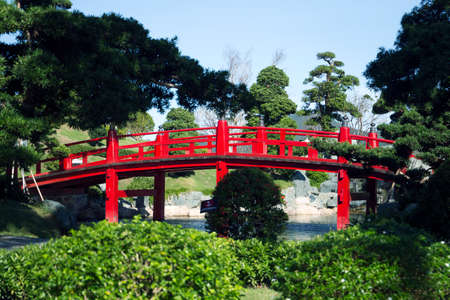 red retro bridge over the river in a traditional Japanese style in a Japanese gardenの写真素材