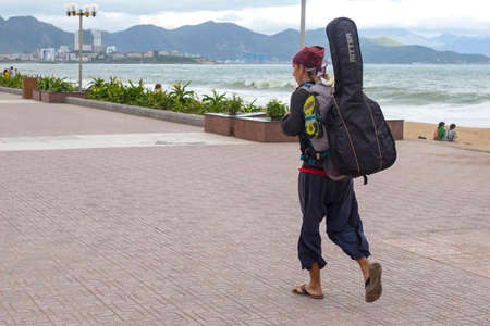 wandering vagabond musician goes near the sea towards the mountains, Vietnam, Nha Trang city 2018-01-10のeditorial素材