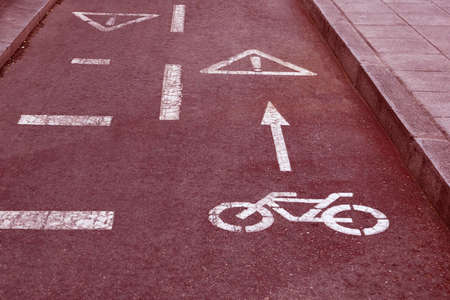 bike path (bicycle lane) sign on the road of the city (red toned, concept of dangerous)の写真素材