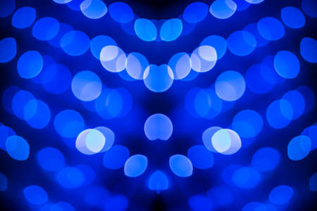 Abstract symmetric glitter defocused blue lights bokeh texture on black background