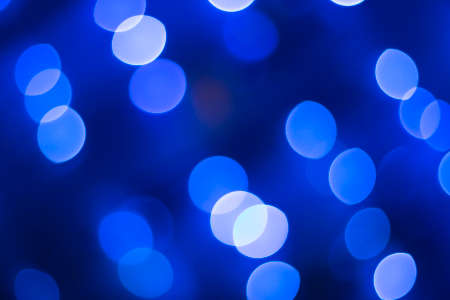 Abstract glitter defocused blue lights bokeh texture on black backgroundの写真素材