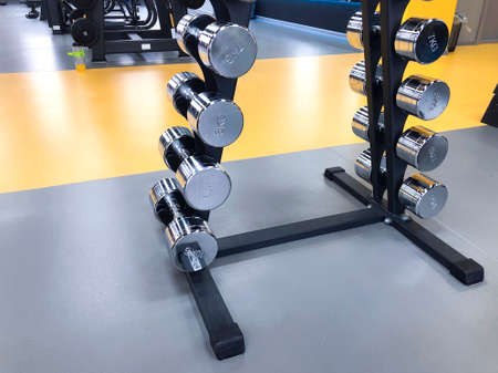 fitness and workout equipment: set of the modern metal steel silver dumbbells on the rackの写真素材