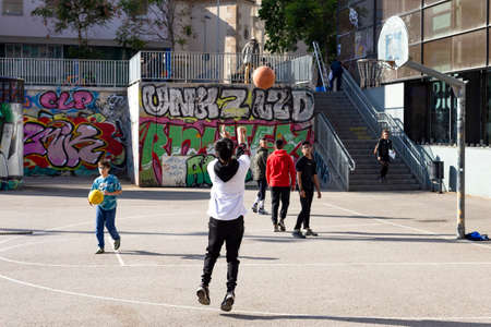 teenagers play street basketball or streetball. Sports, healthy lifestyle and team games in the street of Barcelona, Catalonia, Spain, 30 April, 2019.のeditorial素材