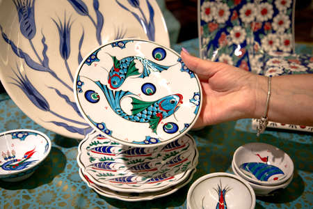 Woman chooses souvenir plate in the market. Souvenirs and gifts shop in Turkey, Istanbul 2019-08-11のeditorial素材