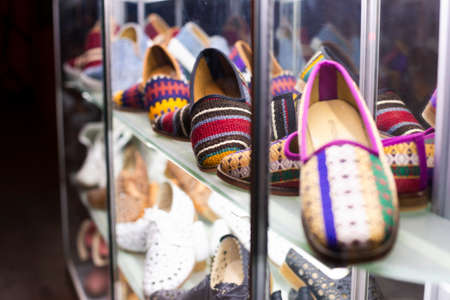 Traditional handmade colorful textile shoes on shop shelf. Popular souvenir from shopping in Istanbul, Turkey 2019-08-13のeditorial素材