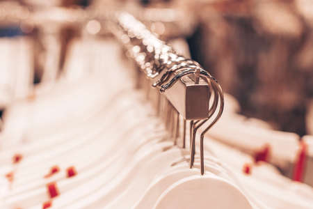 A lot of clothes hangers on the rack in the shop.の写真素材