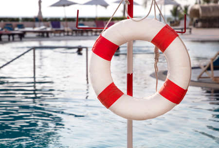Red lifebuoy ring near the swimming pool. Rescue concept.