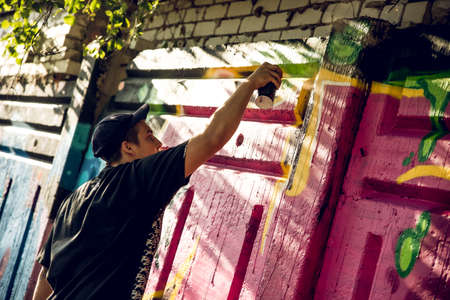 Kharkiv, UKRAINE July 30, 2019: A fellow draws bright street graffiti.のeditorial素材