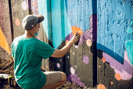 Kharkiv, UKRAINE July 30, 2019: A fellow draws bright street graffiti.のeditorial素材