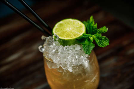 Fresh Mojito cocktail with lime, rosemary, mint and ice in jar glass on. Summer cold drink and...
