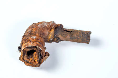 Fragments of old cast-iron water pipes on white background. After many years of operation corroded metal pipe was destroyed. Rusty steel tube with holes of metallic corrosion. Rusty cast iron, metalの写真素材