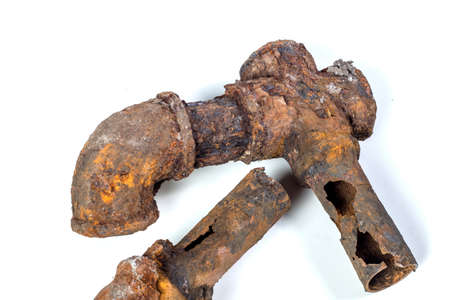 Fragments of old cast-iron water pipes on white background. After many years of operation corroded metal pipe was destroyed. Rusty steel tube with holes of metallic corrosion. Rusty cast iron, metalの写真素材