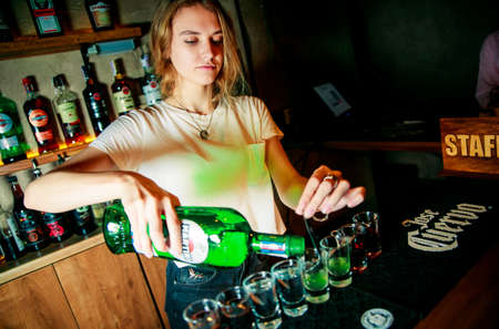 KHARKIV, UKRAINE â JUNE 21, 2019: Brutolny bartender man does pouring whiskeyのeditorial素材