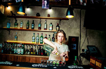 KHARKIV, UKRAINE â JUNE 21, 2019: Barmen girl does pouring whiskeyのeditorial素材