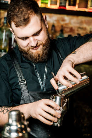 KHARKIV, UKRAINE â JUNE 15, 2019: Brutolny bartender man does pouring whiskeyのeditorial素材