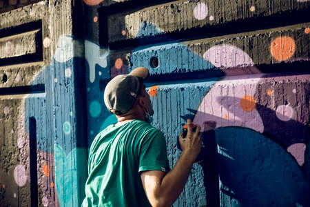 KKARKIV, UKRAINE JULY 30, 2019: A fellow draws bright street graffiti.のeditorial素材