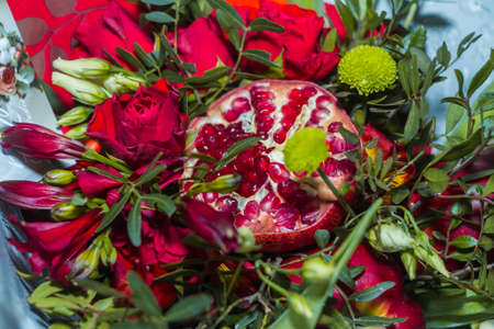 Original gift in the form of a bouquet consisting of roses, pomegranates, plums, grapes on a white background. View from aboveの写真素材
