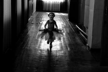 KHARKIV, UKRAINE - MARCH 6, 2019: Cute little girl dreaming of becoming a ballerina. Child girl in a white tutu dancing. Baby girl is studying ballet.のeditorial素材