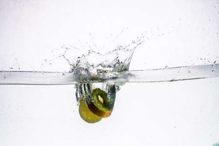 Kiwifruit slice in water with bubbles on white backgroundの写真素材