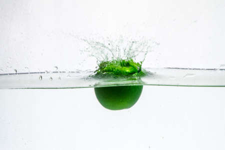 A background of bubbles forming in blue water after apple are dropped into it.の写真素材