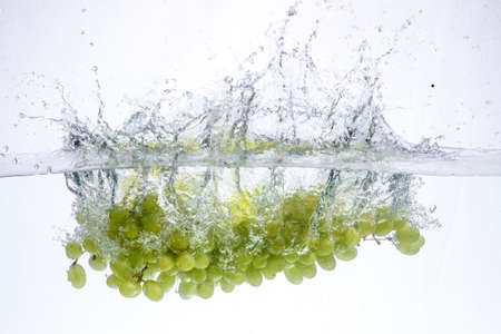 grape in water. splash of water and fruit floating in it.の写真素材