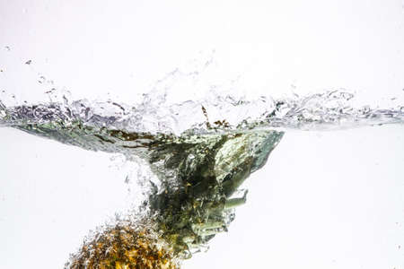 Fresh pineapple jumping into waterの写真素材