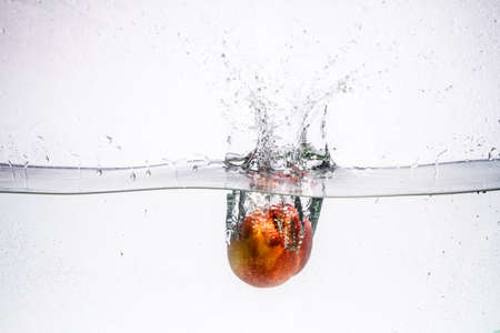 fruit in a spray of water isolated on a white background.の写真素材