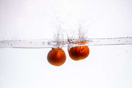 fruit in a spray of water isolated on a white background.の写真素材