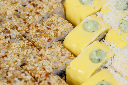 Sushi and rolls home delivery. Krpny plan. Sesame, salmon, cheese.
