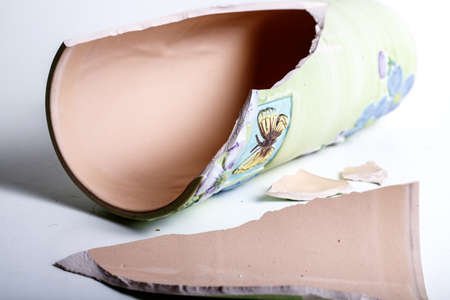 Broken Porcelain Vase Lying on White Background