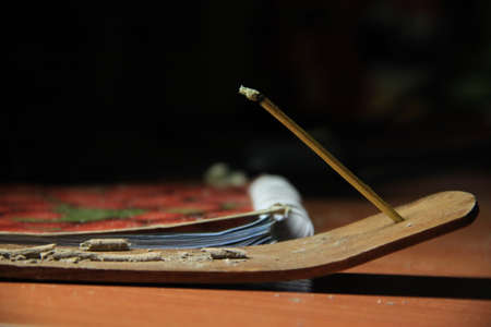 Incense sticks burning iindian agarbatti smoke aroma incense stand burning incense sticks smoke dynamic beautiful calm relax concept Incense on a wooden tableの写真素材