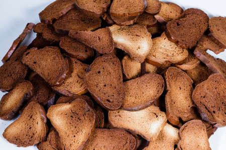 The texture of toasted pieces of bread. Croutons on a white background. Dark dry bread.の写真素材