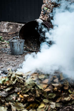 Burning. Autumn bonfire with smoke. Yellow leaves in the smoke.の写真素材