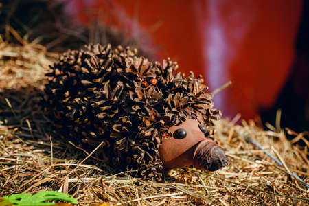 Recycling: a hedgehog and a mushroom made of plastic bottles in a garden. Hedgehog from cones with their own hands.の写真素材