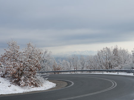 Winter landscape with road and snow-covered trees in the mountains.の写真素材