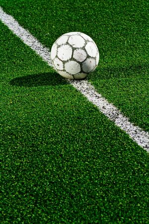 Old soccer ball on green grassの写真素材