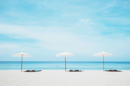 beach chairs on the white sand beach and blue seaの写真素材