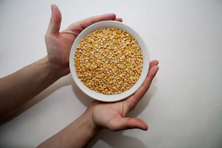 Hands hold a dish with peas. It is a meal theme.の写真素材