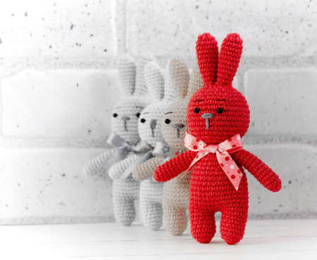 A group of knitted rabbits stands together. This is a knitted toy theme.の写真素材