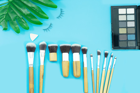 Makeup brushes, everyday make-up tools on blue background. Concept of beauty fashion.の写真素材