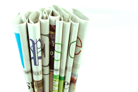 Newspapers folded and stacked isolated on white backgroundの写真素材